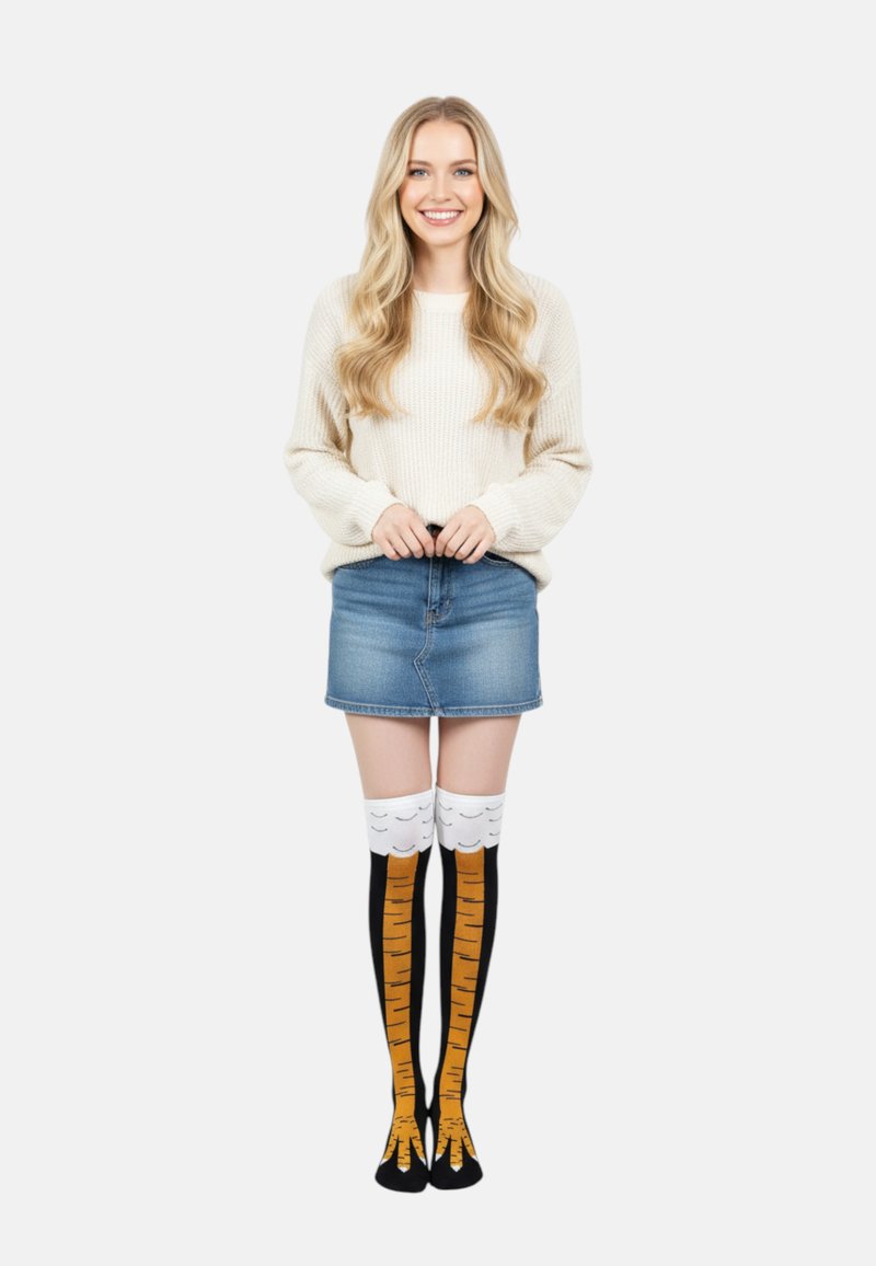 Kniesokken met een zwarte basis, oranje strepen die lijken op de vacht van een tijger, en een witte top met kleine zwarte accenten. Draagt het met een spijkerrok.