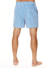 Shorts de bain rayés bleus et blancs avec une ceinture élastique, des poches latérales et une poche arrière, fabriqués en tissu léger.