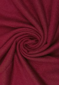 Tessuto bordeaux, texture morbida, finemente tessuto, disposto in un motivo a spirale, che mostra una superficie liscia e uniforme.