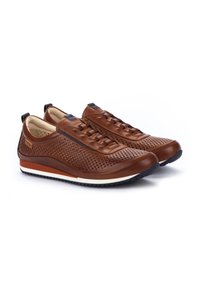Sneakers in pelle marrone con tomaia perforata, dotati di lacci piatti, plantare imbottito e suola in gomma bianca con un motivo testurizzato.