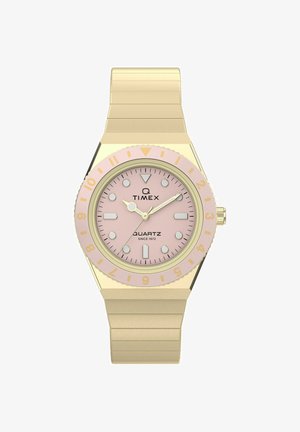Zlaté náramkové hodinky Timex s quartzovým strojčekom, ružovým ciferníkom, zlatými ručičkami, guľatými a obdĺžnikovými indexmi hodín a ružovým rámikom s číslami zlatého odtieňa.