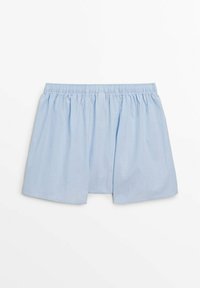 Shorts en coton bleu clair avec un waistband élastique, présentant une coupe ample et deux fentes latérales pour un confort et une respirabilité accrus.