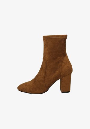 Stivale alla caviglia in suede marrone con punta affusolata e tacco grosso. Presenta un albero aderente e un design senza cuciture con dettagli di cucitura visibili.