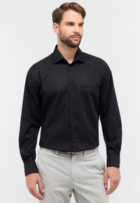 Camicia nera a maniche lunghe con colletto a bottoni, tasca singola sul petto e polsini decorati, realizzata in un tessuto liscio e leggero.