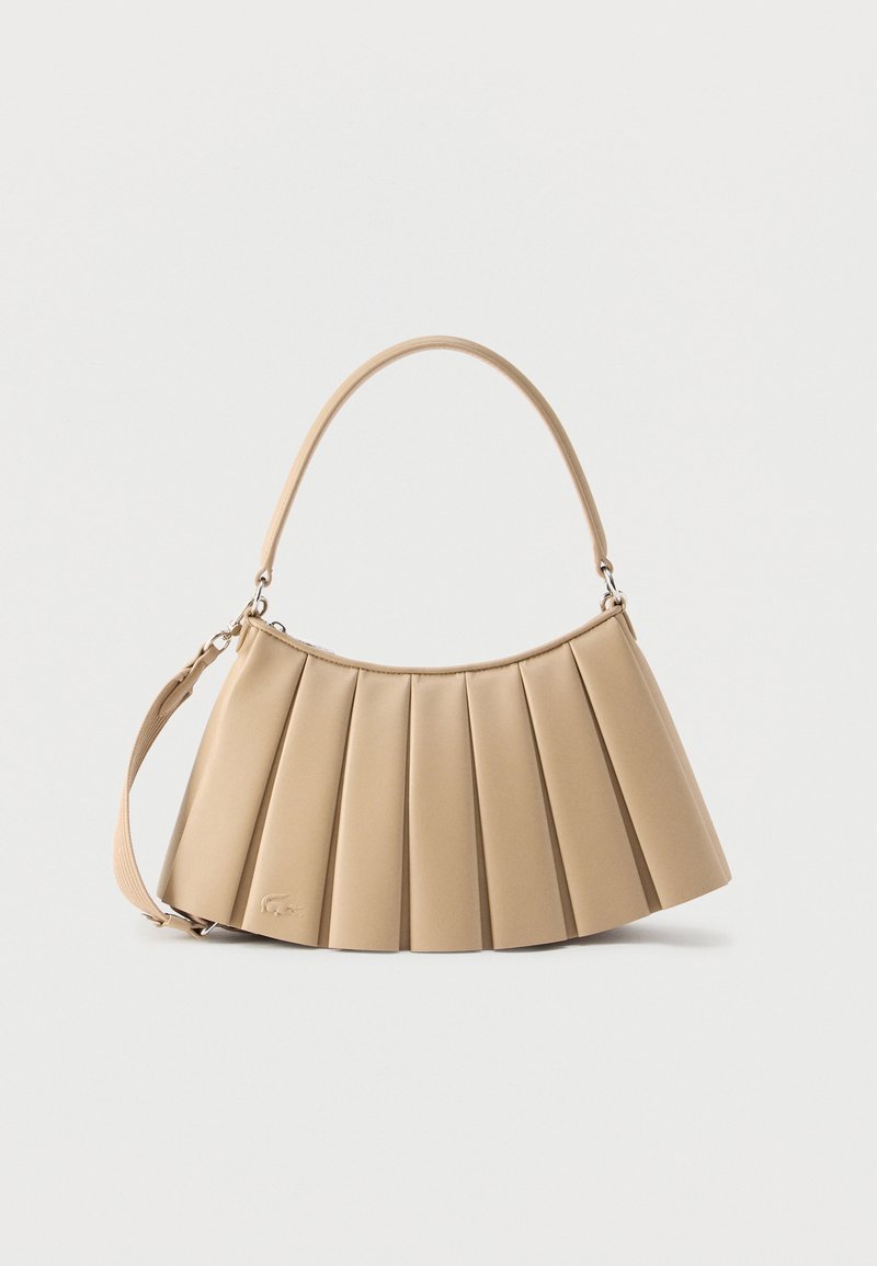 Μπεζ τσάντα ώμου με πιέτες, στρογγυλεμένη πάνω λαβή και αφαιρούμενο λουράκι, κατασκευασμένη από λείο δέρμα με διακριτική λεπτομέρεια λογότυπου κοντά στη βάση.