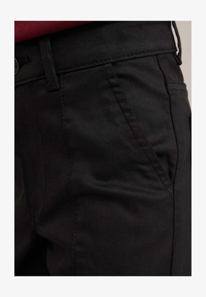 Pantaloni negri dintr-un material neted, cu o croială slim. Prezintă o buzunar frontal, o talie vizibilă cu un nasture și cusături în contrast.