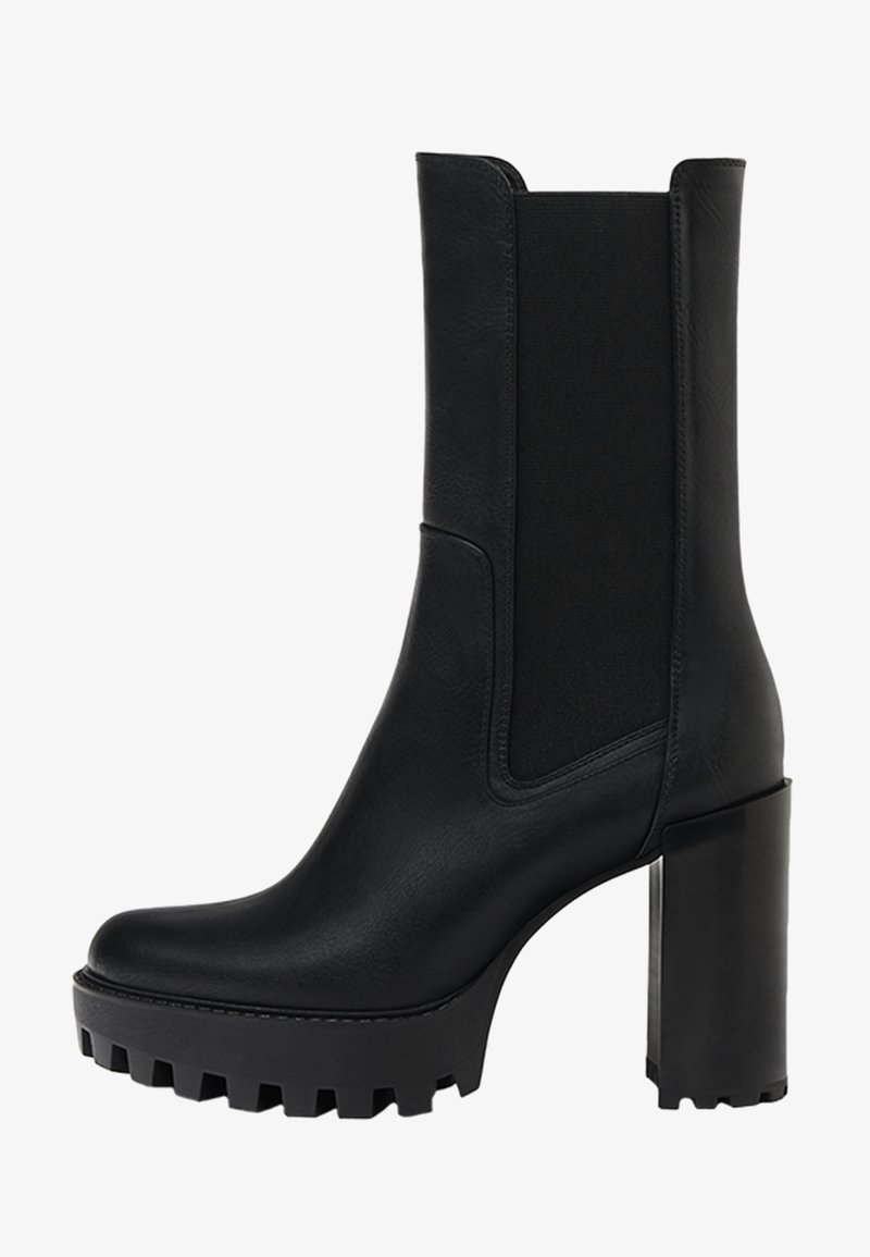 Botte noire en cuir mi-mollet avec panneau élastique sur le côté, semelle crantée épaisse et talon haut carré pour allier style et adhérence.