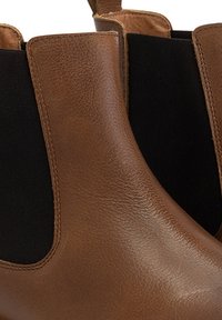 Bruine leren Chelsea-laarzen met elastische zijkanten en een zachte afwerking. Het ontwerp heeft een ronde neus en een enkelhoog silhouet.