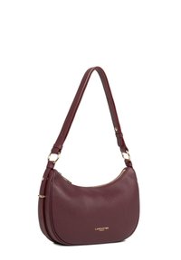 Borsa hobo in pelle bordeaux con forma curvata, hardware dorato e tracolla regolabile; presenta una chiusura con zip e un dettaglio del logo in rilievo.