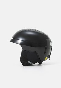 Zwarte skihelm met een gladde schaal en geventileerd ontwerp. Beschikt over een verstelbare kinband en het MIPS-logo voor extra veiligheid.
