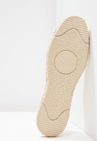 Sneaker-Sohle in Beige mit einer strukturierten, gummierten Oberfläche. Größe 36 in einem kreisförmigen Bereich markiert. Glatter Akzent an der Zehen- und Ferse.