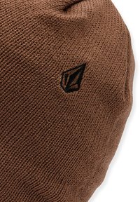 Brown knit beanie with a textured pattern. Features a small black logo on one side, rounded shape, and a soft, flexible material.