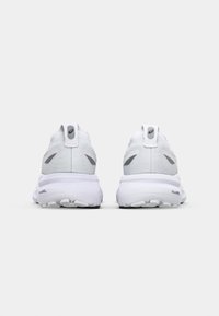 Baskets de sport blanches avec un dessus en tissu texturé, de subtils accents gris et une semelle rembourrée dotée d'une technologie de gel visible.