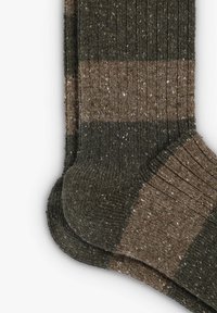 Calcetines de color marrón con rayas en verde oscuro y marrón claro, presentan un patrón de tejido texturizado y motas a lo largo.
