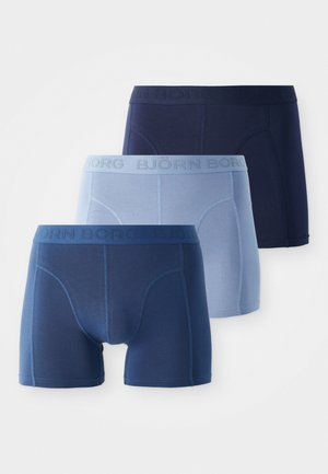 Drei Paar Björn Borg Herrenboxershorts in Dunkelblau, Hellblau und Marineblau, in einer geschichteten Reihe angeordnet.