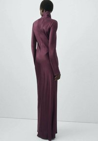 Long-sleeved, high-neck dress in deep burgundy, form-fitting with a smooth, stretchy texture, highlighting the silhouette and clean lines.