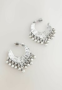 Sølv øreringe i hoop-design med tekstureret overflade og rund form, der har hængende sølvperler nederst for ekstra detalje.