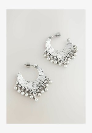 Silberne Creolen mit einem strukturierten Design und abgerundeter Form, versehen mit hängenden silbernen Perlen am unteren Rand für zusätzliche Details.