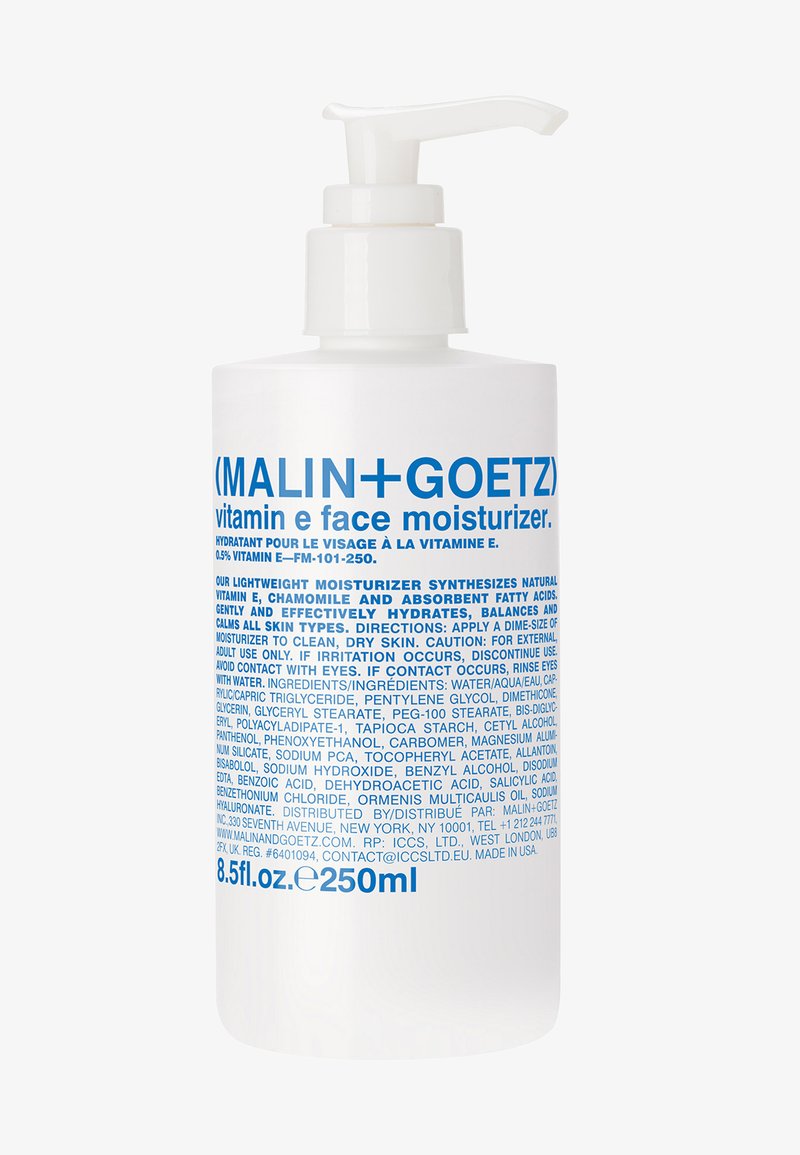 Weißer Pumpbehälter mit der Aufschrift "(MALIN+GOETZ) Vitamin E Gesichtsfeuchtigkeit" in blauer Schrift. 250 ml Kapazität, glatte Oberfläche, schlichtes Design.