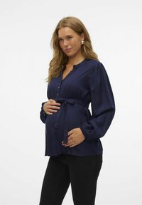 Blusa de maternidad de manga larga en azul marino, hecha de tela suave, con una tapeta de botones, cintura ajustada con lazo y mangas fruncidas.