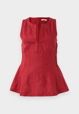 Haut sans manches rouge en lin. Caractéristiques : col montant, fermeture éclair à l'avant, corsage ajusté et ourlet évasé avec des détails de panneau latéral.