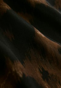 Textil anyag fekete alapon, barna és bézs absztrakt mintával, sima textúrával és finom fényességgel.