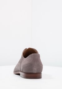 Šedá nubuková bota s texturovaným povrchem, kulatou špičkou a nízkým dřevěným podpatkem, se jednoduchým designem a bez viditelného kování.