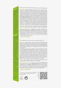 Bioderma Sébium Pore Refiner, un gel trasparente in una bottiglia rettangolare, con una texture liscia, caratterizzato da testo verde e una descrizione concisa del prodotto.