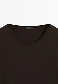 Donkerbruine, geribde T-shirt met een ronde halslijn. Ilabel zegt "Massimo Dutti." Houdt een gladde textuur aan, zonder zichtbare patronen of accenten.