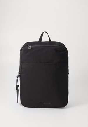 Zaino nero dal design elegante, realizzato in tessuto resistente, con manico superiore, tasca frontale con zip e logo Tommy Hilfiger.