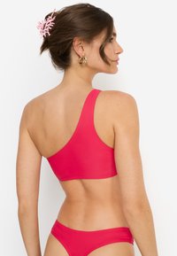 Knallpinker Bikini-Set mit asymmetrischem Ein-Schulter-Oberteil und passenden Unterteilen. Glattes, dehnbares Material; minimalistisches Design mit klaren Kanten.