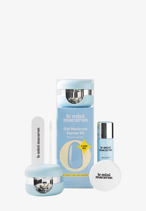 Kit de inicio para manicura de gel con mini lámparas LED, esmalte en gel, lima de uñas y recipiente para removedor en embalaje azul pastel y blanco.