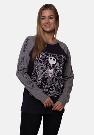 Dark blue long-sleeve shirt with gray raglan sleeves featuring white graphic of characters from "The Nightmare Before Christmas." Text on sleeve reads "Before Christmas."