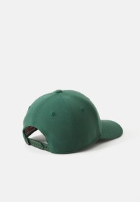 Zöld baseball sapka, amely textilből készült, lekerekített koronával, ívelt csúccsal és állítható pánttal a hátsó részen. Egyszerű, mintás design.