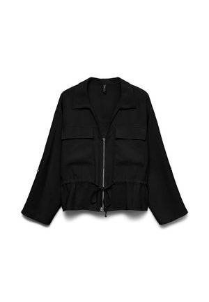 Sort lynlåstrøje med forlommer med klap, snøre i taljen, vide ærmer og krave, vist på hvid baggrund.