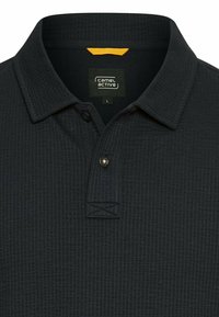 Mørkeblå polo skjorte lavet af tekstureret materiale, med krave, knaplukning og orange detalje ved kraven.