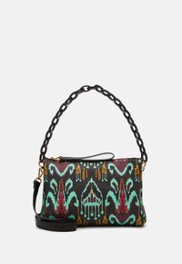 Sac à main avec un extérieur noir à motifs, présentant des designs géométriques colorés en rouge, vert et jaune, avec une chaîne et une bandoulière amovible.