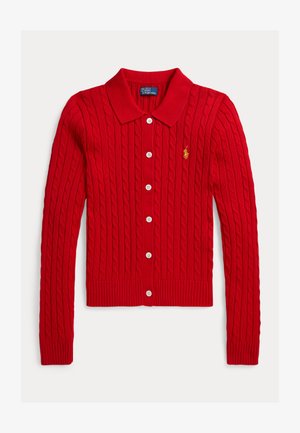 Czerwony sweter rozpinany na drutach z wzorem warkocza, kołnierzem i sześcioma białymi guzikami. Posiada ściągacze na mankietach i dole oraz małe logo na lewej piersi.