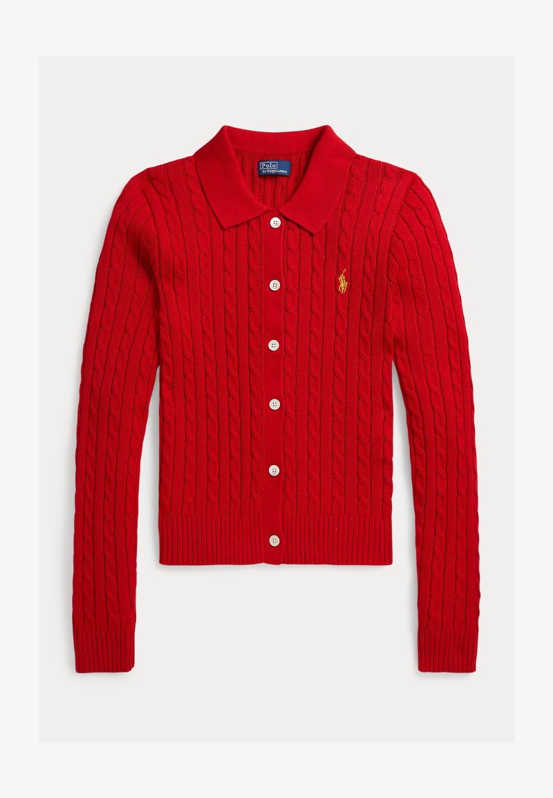 Czerwony sweter rozpinany na drutach z wzorem warkocza, kołnierzem i sześcioma białymi guzikami. Posiada ściągacze na mankietach i dole oraz małe logo na lewej piersi.