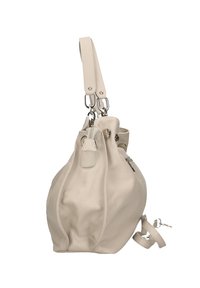 Sac à main en cuir beige avec une forme arrondie, doté d'une sangle d'épaule amovible et d'accents métalliques argentés. Surface texturée avec des détails de couture.