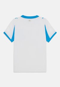 Fehér, rövid ujjú ing, kék díszítéssel az ujjakon és a galléron. Könnyű anyagból készült, finom mintázati elemekkel.