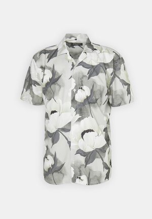 Kratkoročna srajca z gumbi iz lahkega materiala, okrašena z cvetličnim vzorcem v odtenkih bele, sive in črne na zatemnjenem ozadju.