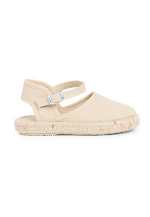 Tan espadrille sandaal met canvas bovenwerk, verstelbare enkelriem en gevlochten jute zool. Rond punt met een platte profiel.