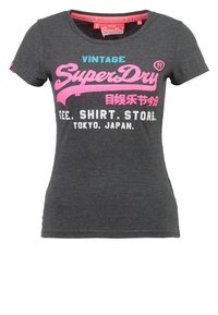 Grå bomull t-shirt med kort ärm och rund hals. Har rosa och blå silkscreentryckt text: "VINTAGE SuperDry," "Tee Shirt Store, Tokyo."