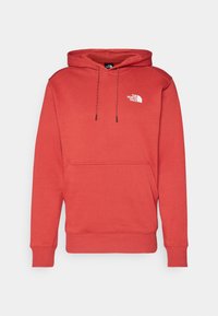 Hoodie in leuchtendem Rot, mit einer vorderen Kängurutasche, gerippten Bündchen und einem kleinen weißen Logo auf der Brust. Weicher Stoff.