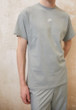 Lys grøn bomulds t-shirt med korte ærmer, rund hals og et lille hvidt Nike-logo på brystet, parret med matchende bukser.