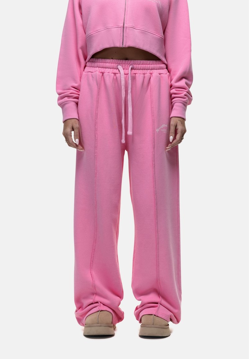 Roze sweatshirt met een cropped ontwerp en rits aan de voorkant, gecombineerd met losse roze sweatpants met een drawstring taille en zijnaadstiksels.