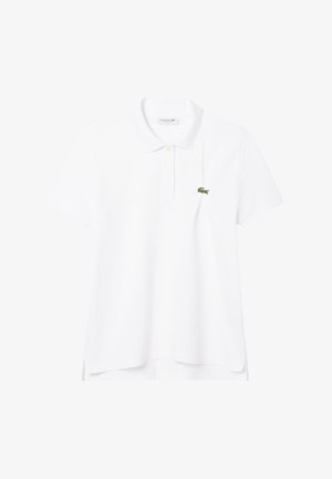 Camisa polo blanca de algodón, con un cuello clásico, mangas cortas y un pequeño logo de cocodrilo verde en el lado izquierdo del pecho.