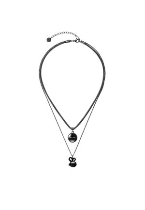 Dva černé vrstvené náhrdelníky, jeden s kulatým přívěskem s vyrytým nápisem "Bee Me", druhý s malým přívěskem ve tvaru včely.