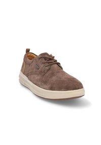 Zapatos de ante marrón con cordones, suela de goma beige clara, puntera redondeada y detalles de tela en el talón y la lengüeta. Presenta cordones marrones.